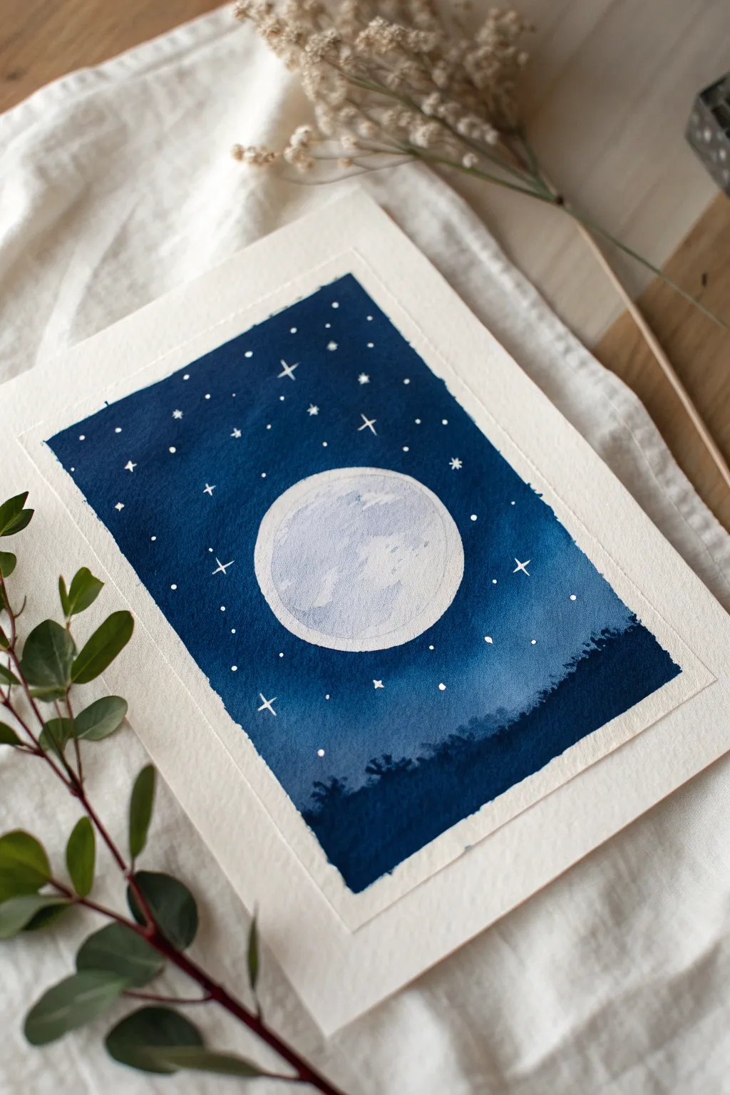 Minimal gouache night sky: bright full moon and delicate white stars on rich indigo.