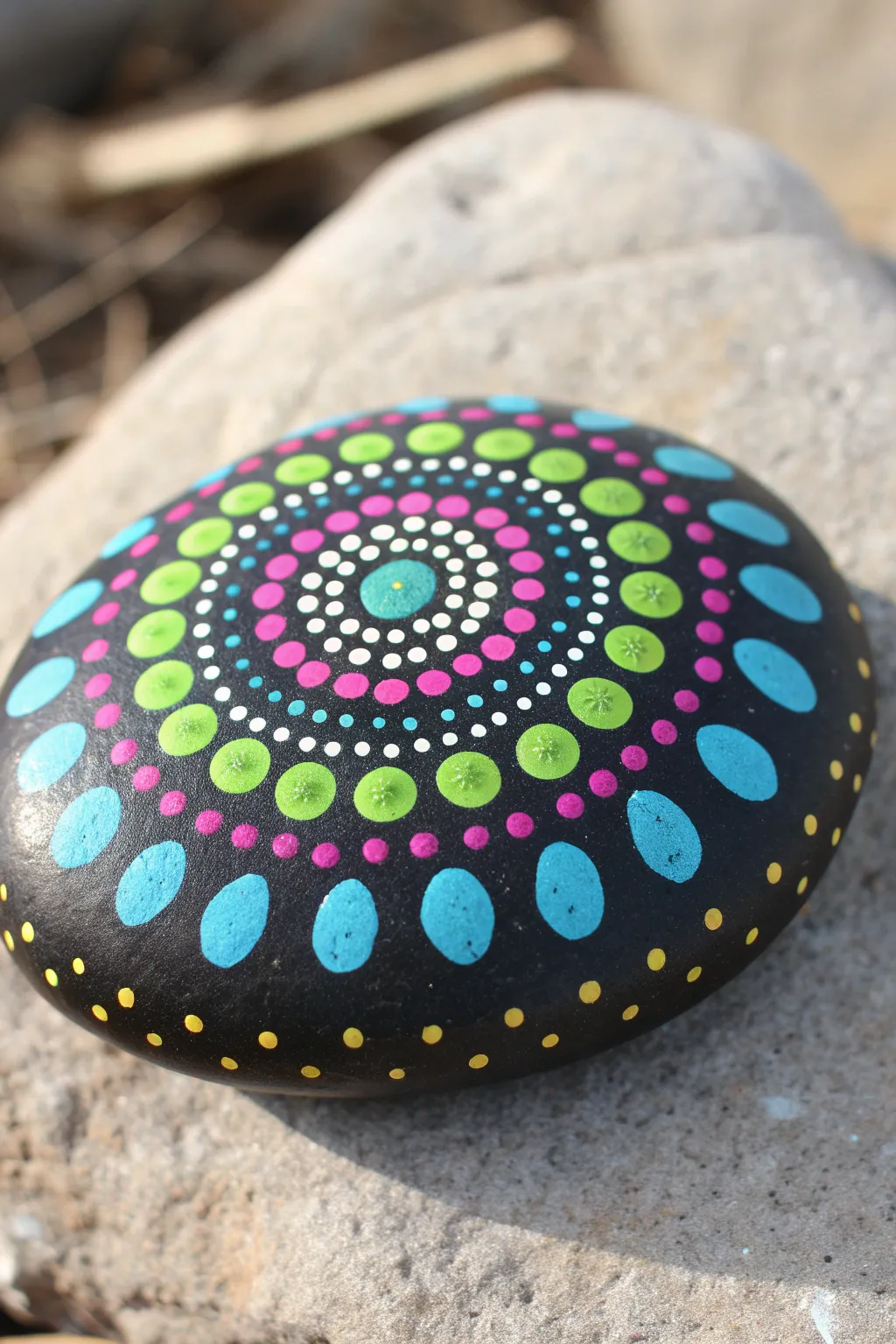 Solid black rock mandala with bright dot rings, a bold high-contrast painting idea