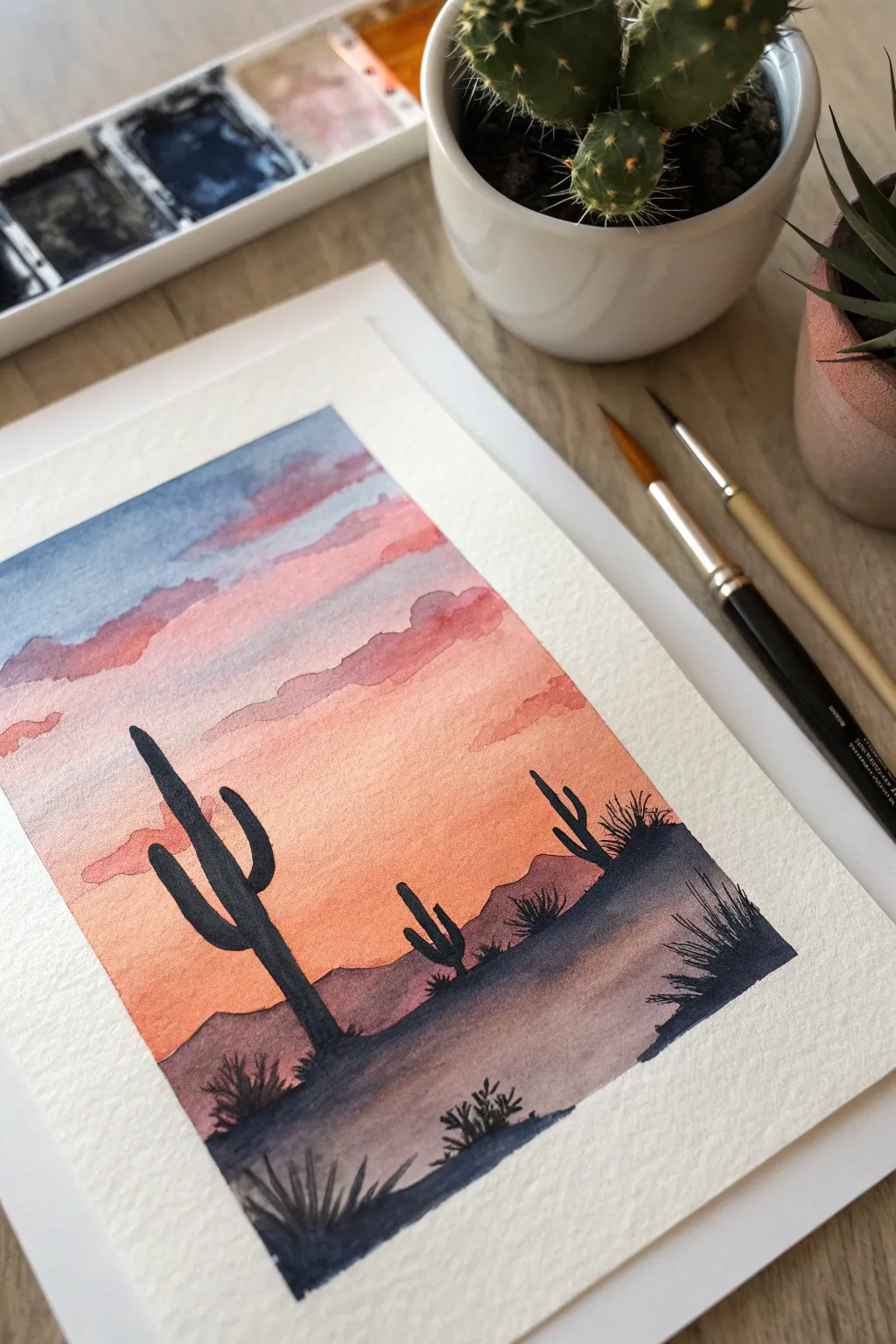 High-contrast desert sunset cactus silhouette painting, minimalist setup with brush nearby for easy inspo.