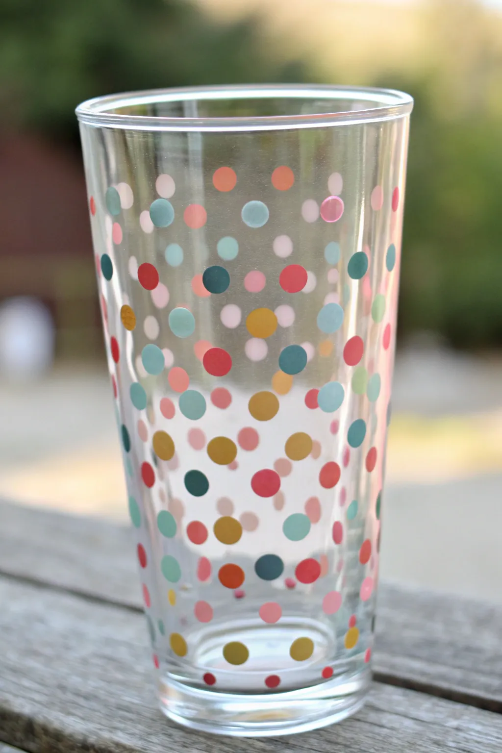Classic confetti polka dots on a glass tumbler, close-up texture and luminous shine.