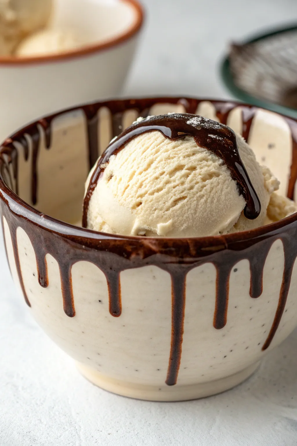 Glossy chocolate drip rim on a vanilla-toned bowl, minimal and handcrafted with bold contrast