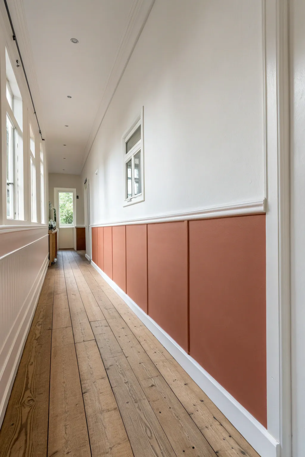 Half-painted dipped wall for instant contrast, with tape and a stool for an easy Scandinavian DIY vibe.