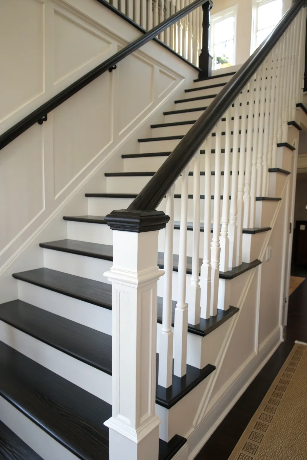 Crisp contrast: matte black handrail and clean white spindles with sharp, crafted paint lines