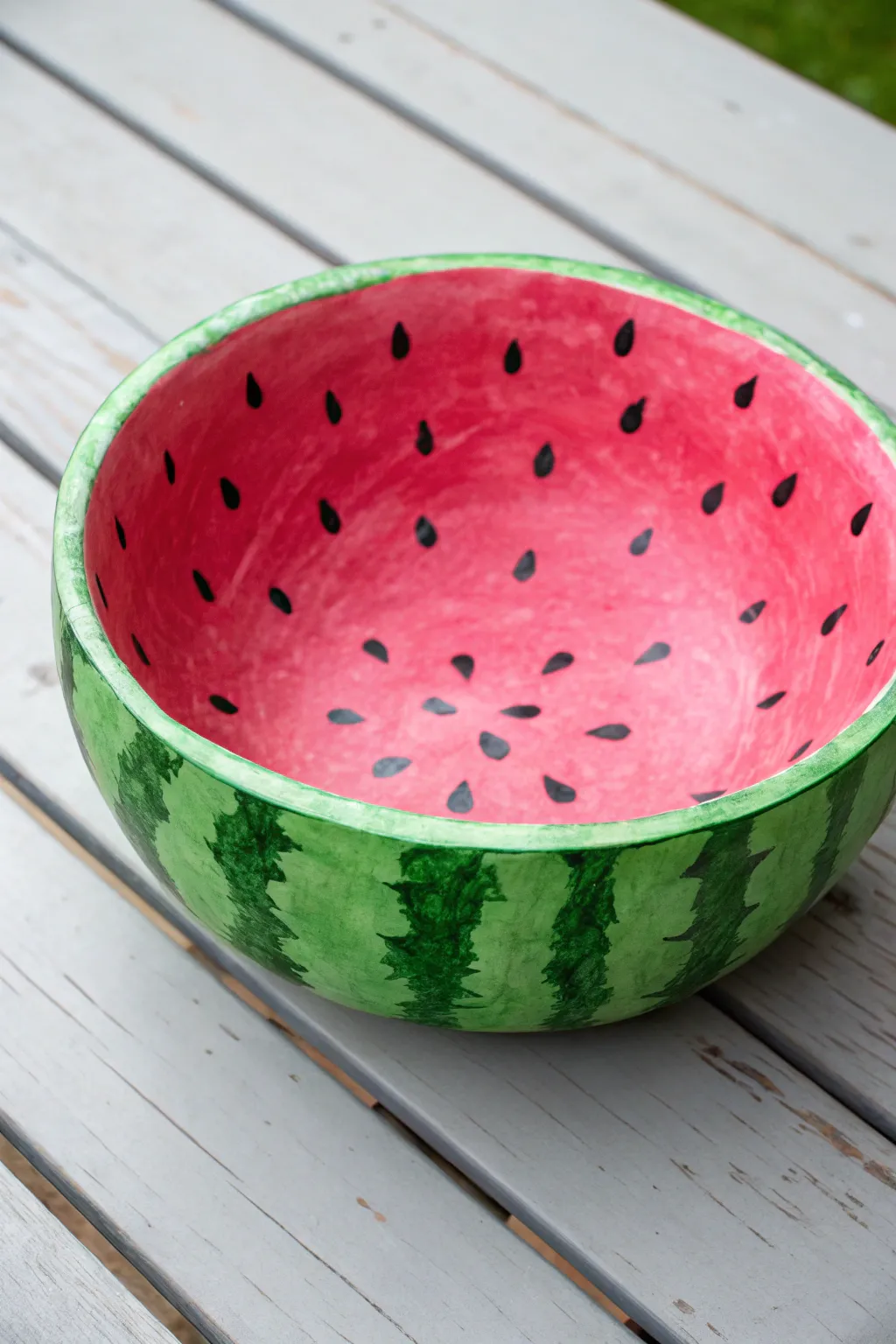 Paint a paper mache bowl into a watermelon slice catchall with bold contrast and sweet seeds