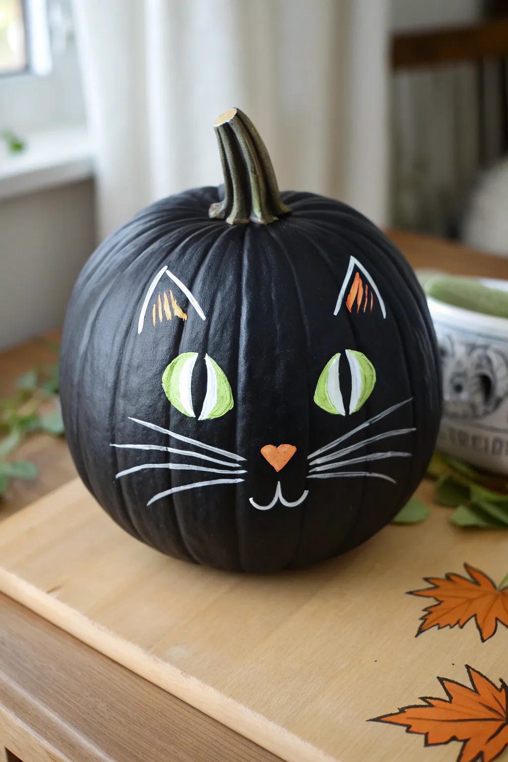 Matte black cat pumpkin with neon-green eyes, minimalist styling, and a dramatic shadow