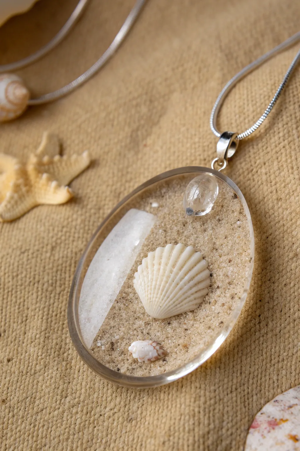 Beachy resin pendant with sand and a tiny shell, styled simply for minimalist boho vibes