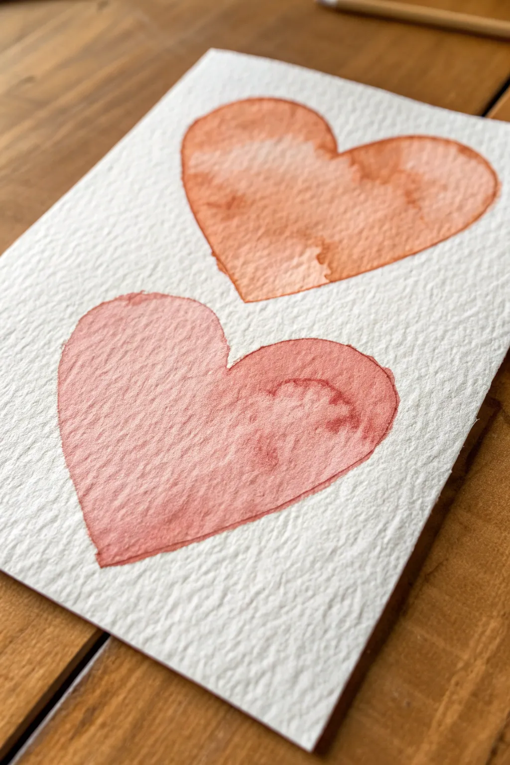 Two overlapping hearts in blush and terracotta, a simple cute minimalist painting idea to copy.