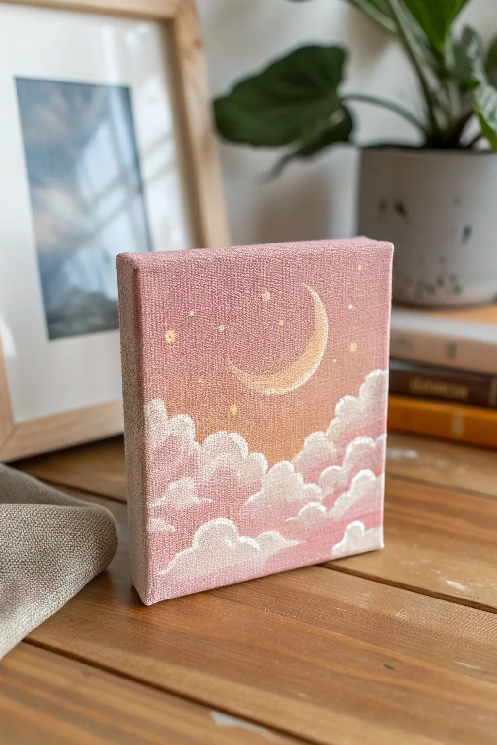 Soft moon over blush clouds on a small canvas, minimalist Scandinavian boho, dreamy and airy.