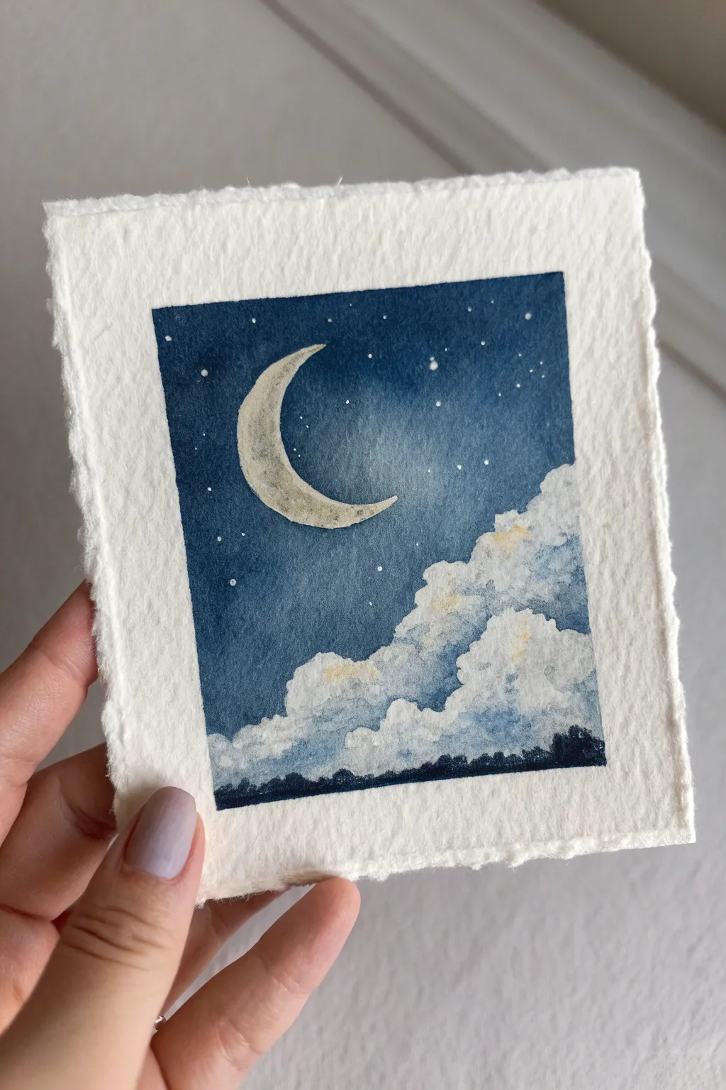 Tiny moon painting idea: soft indigo sky, pale crescent moon, and dreamy clouds in calm harmony