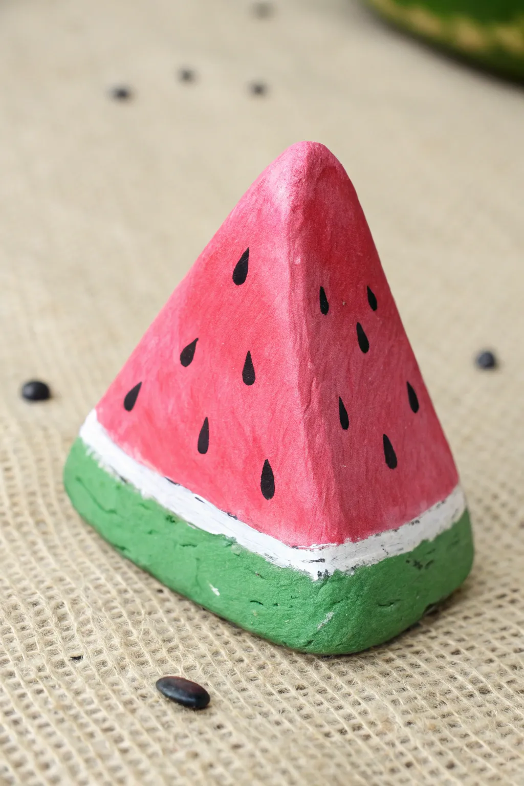 Triangle rock painted as a juicy watermelon wedge with crisp seeds and fresh green rind