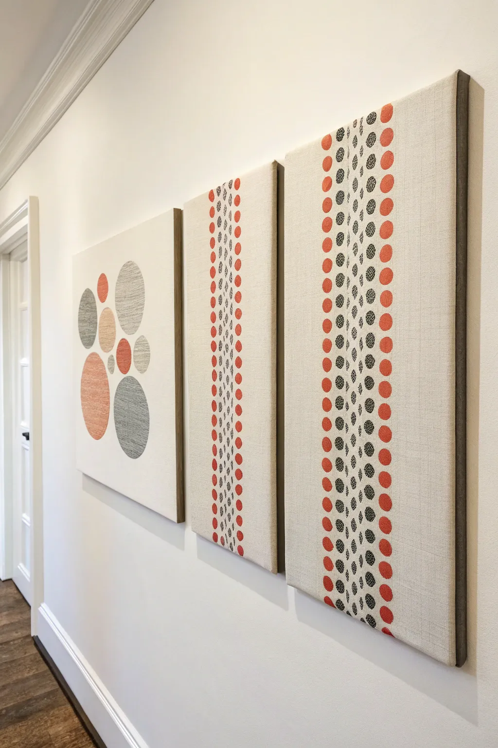 Monochrome canvas trio with a tiny coral pop for a calm Scandinavian wall statement.