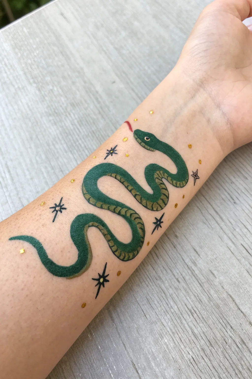 Easy one-stroke snake arm paint: curvy S-line body, tiny tongue, and subtle sparkle dots