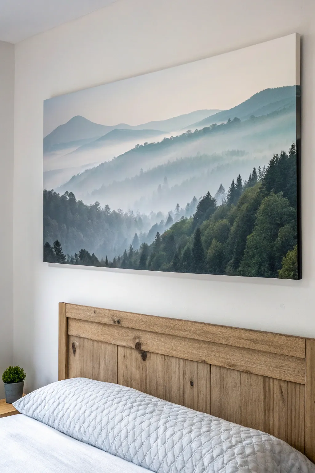 Misty mountain silhouette canvas adds calm foggy grays and muted greens above a cozy bed glow.