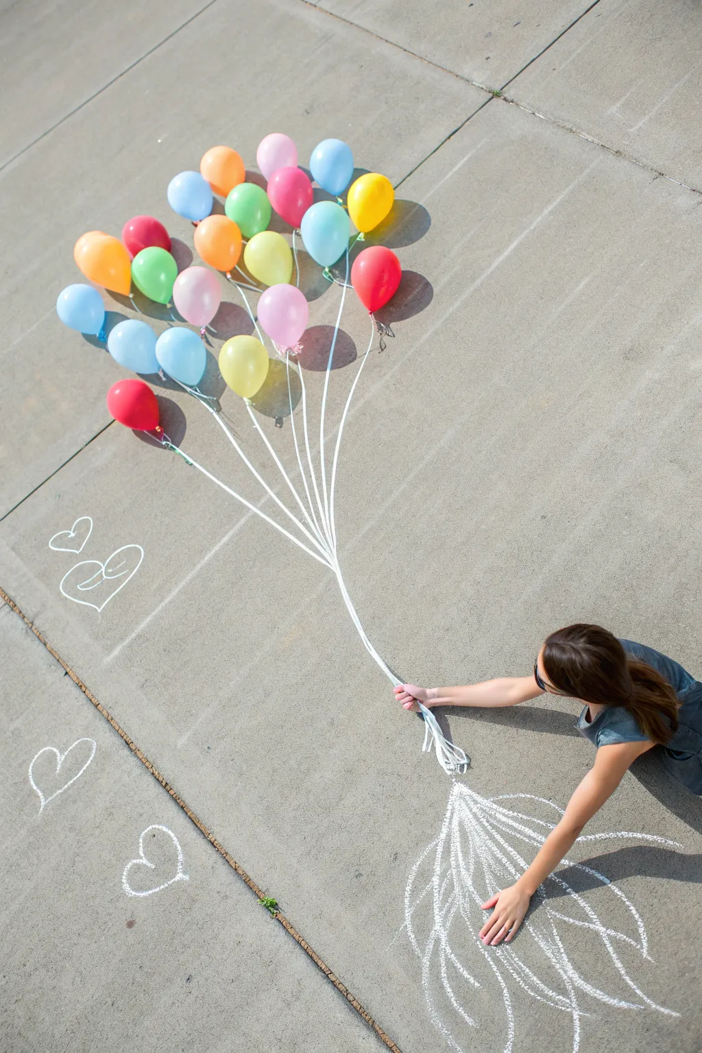 Up-and-away chalk balloon bouquet illusion, vivid balloons and clean strings in a crisp top-down shot.