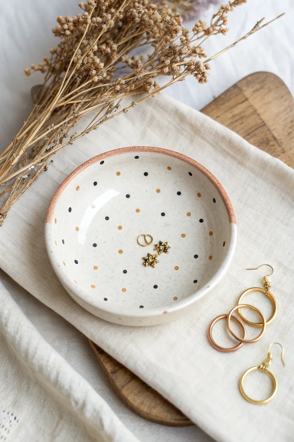 Classic polka dots and dashes on a minimalist jewelry dish with tiny stud earrings