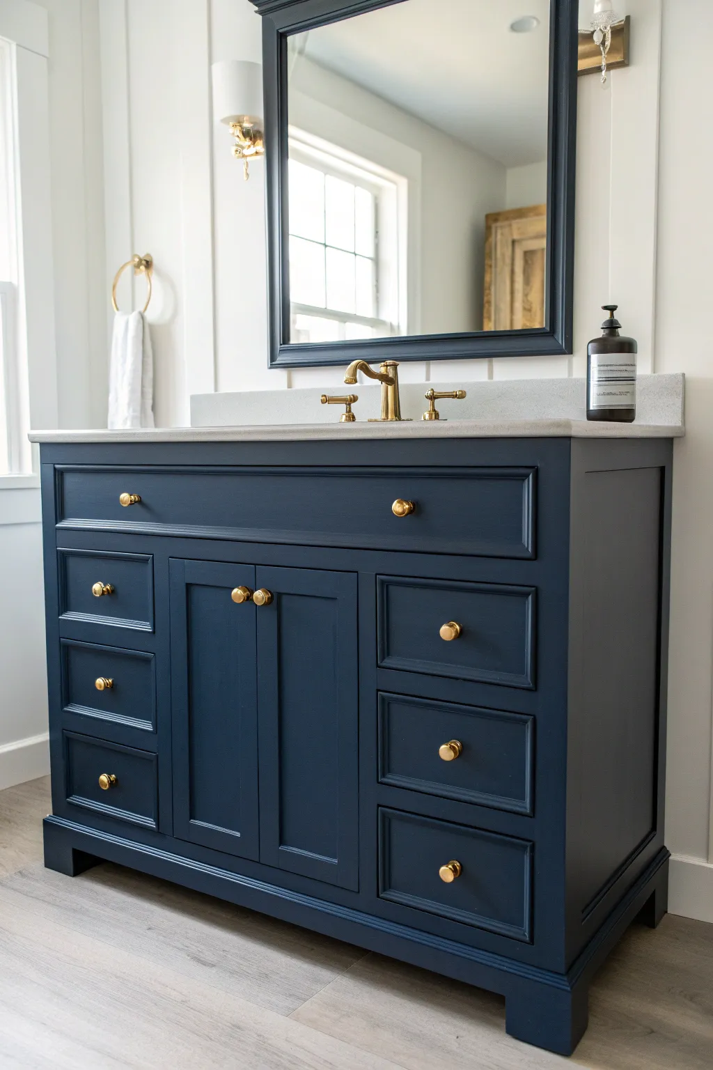 Moody navy antique vanity with warm brass pulls and soft daylight for timeless painted charm.