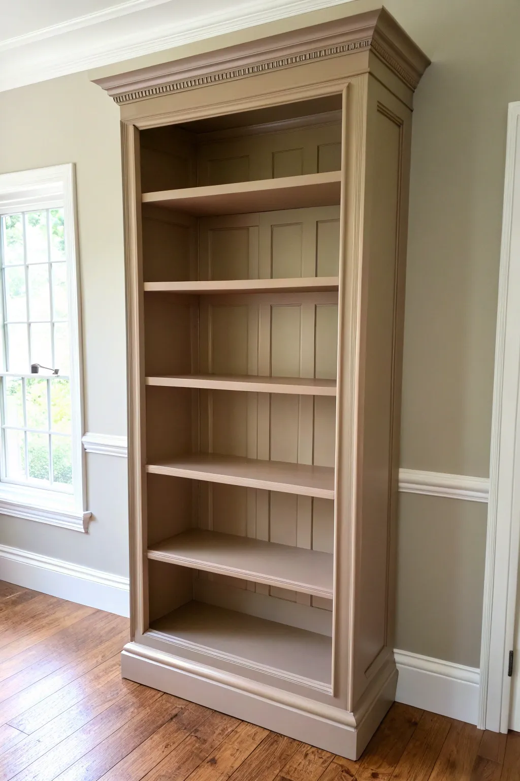 Monochrome built-in vibe: a painted bookcase matching wall and trim for a seamless, serene look.