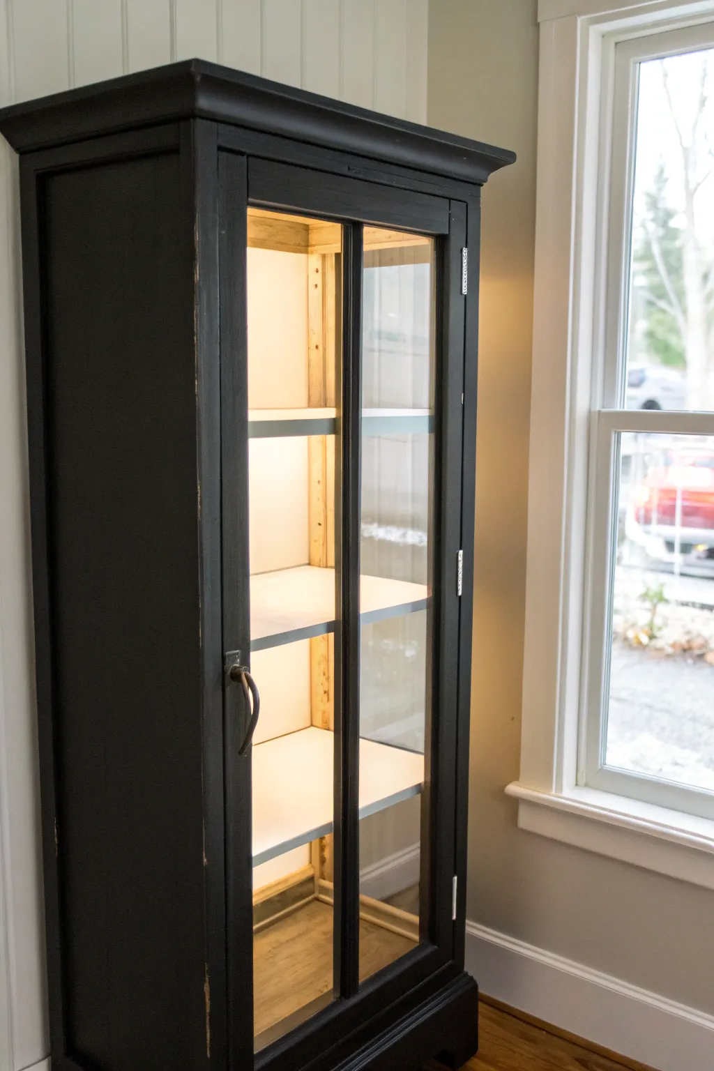 Crisp black curio cabinet with a glowing white interior for clean, striking shelf contrast.