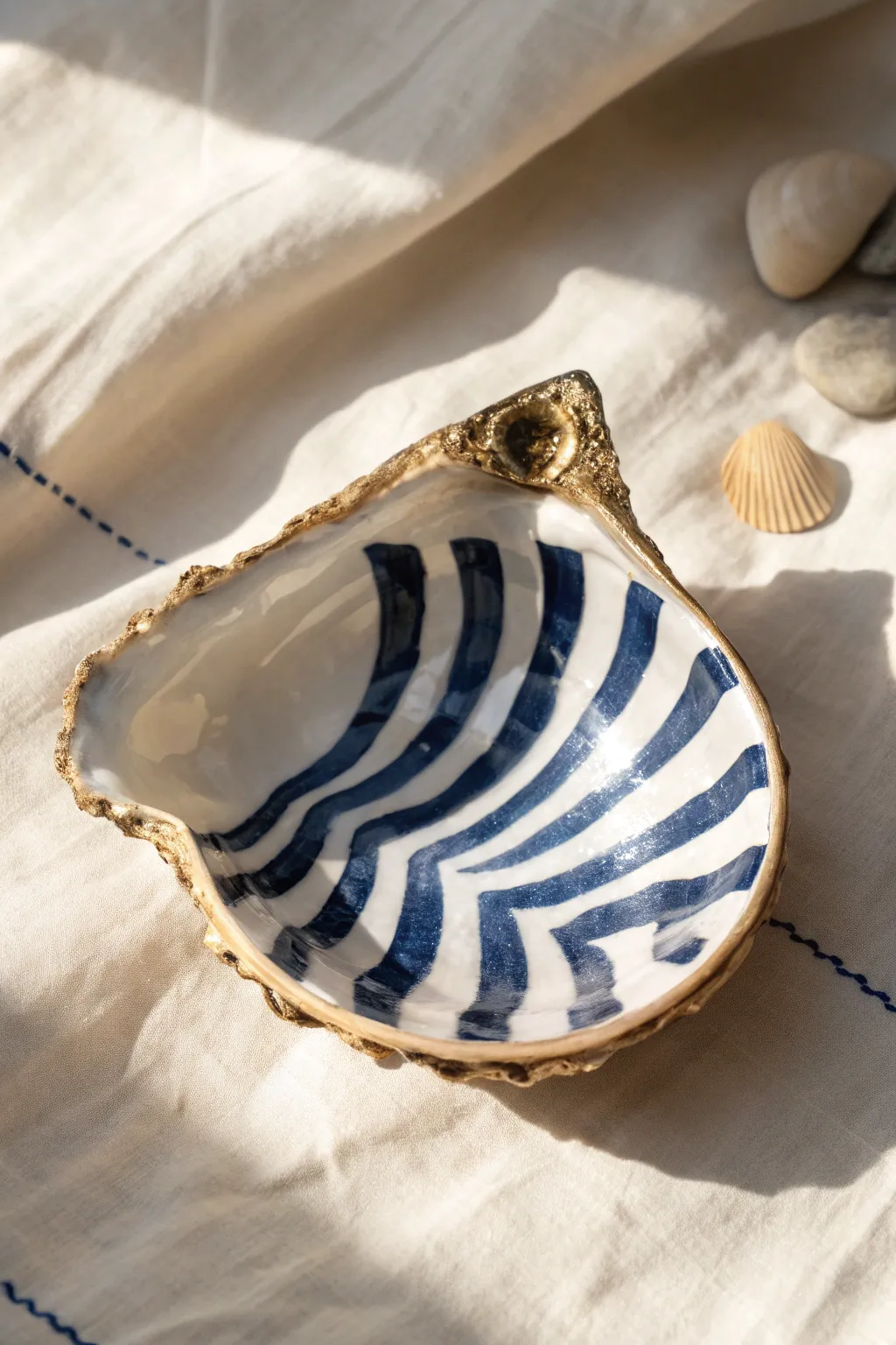 Coastal stripe oyster shell with a metallic rim, minimal Scandinavian styling and bold contrast.
