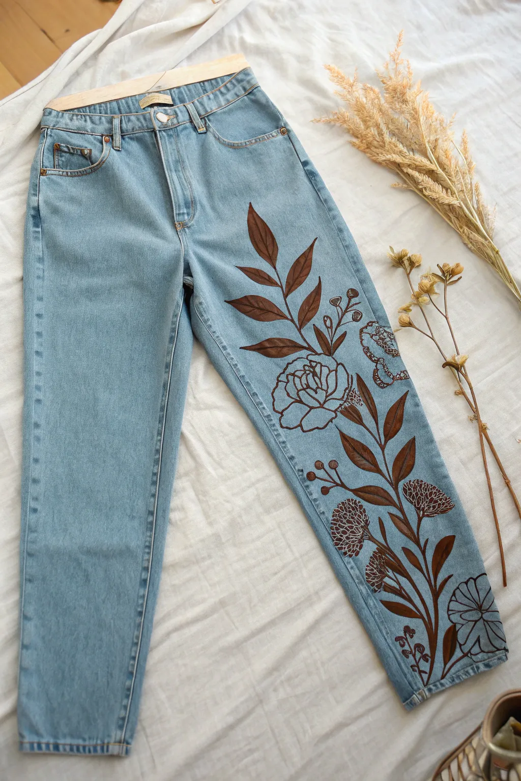 One leg bold, one leg bare: minimalist jeans flat lay with a striking hand-painted panel