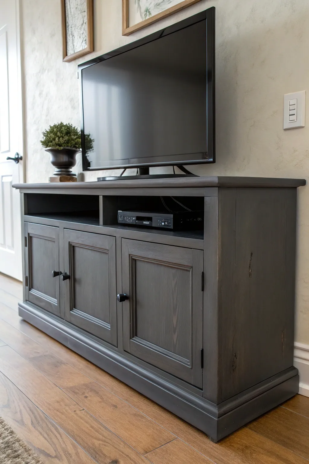 Matte charcoal TV stand with dark hardware brings moody modern contrast to minimalist decor