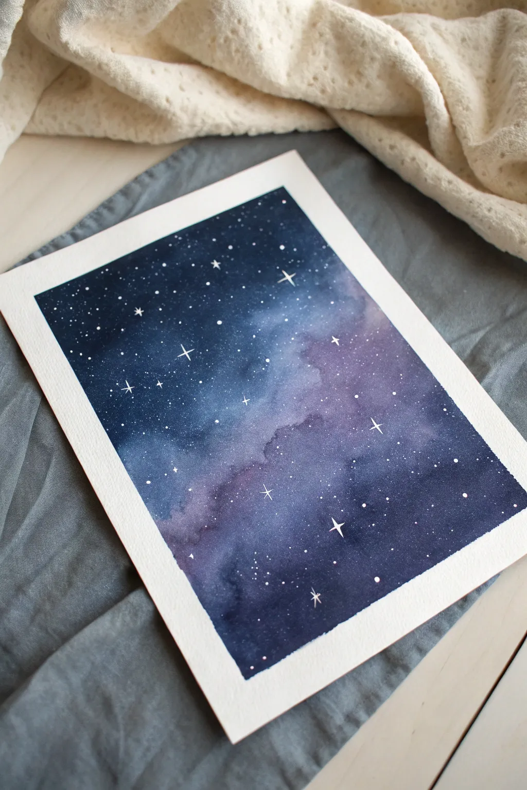 Deep indigo galaxy wash with crisp white splatter stars on neatly taped watercolor paper