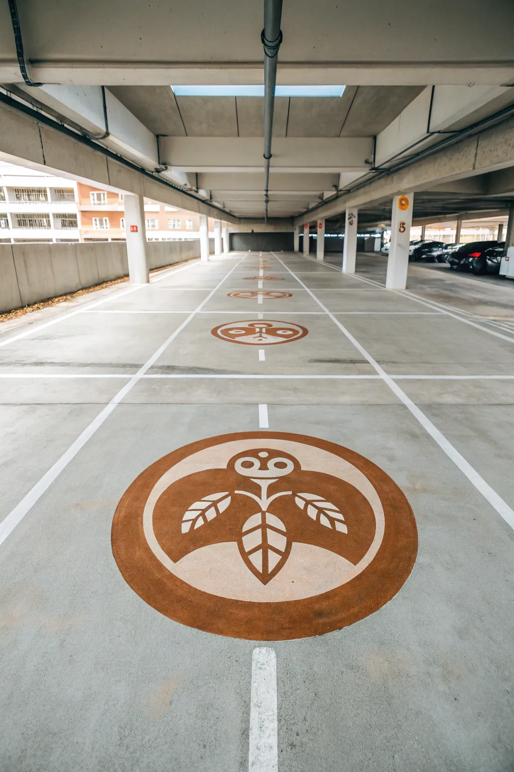 Minimalist mascot emblem centered in a parking stall, a chic DIY focal point with boho warmth.