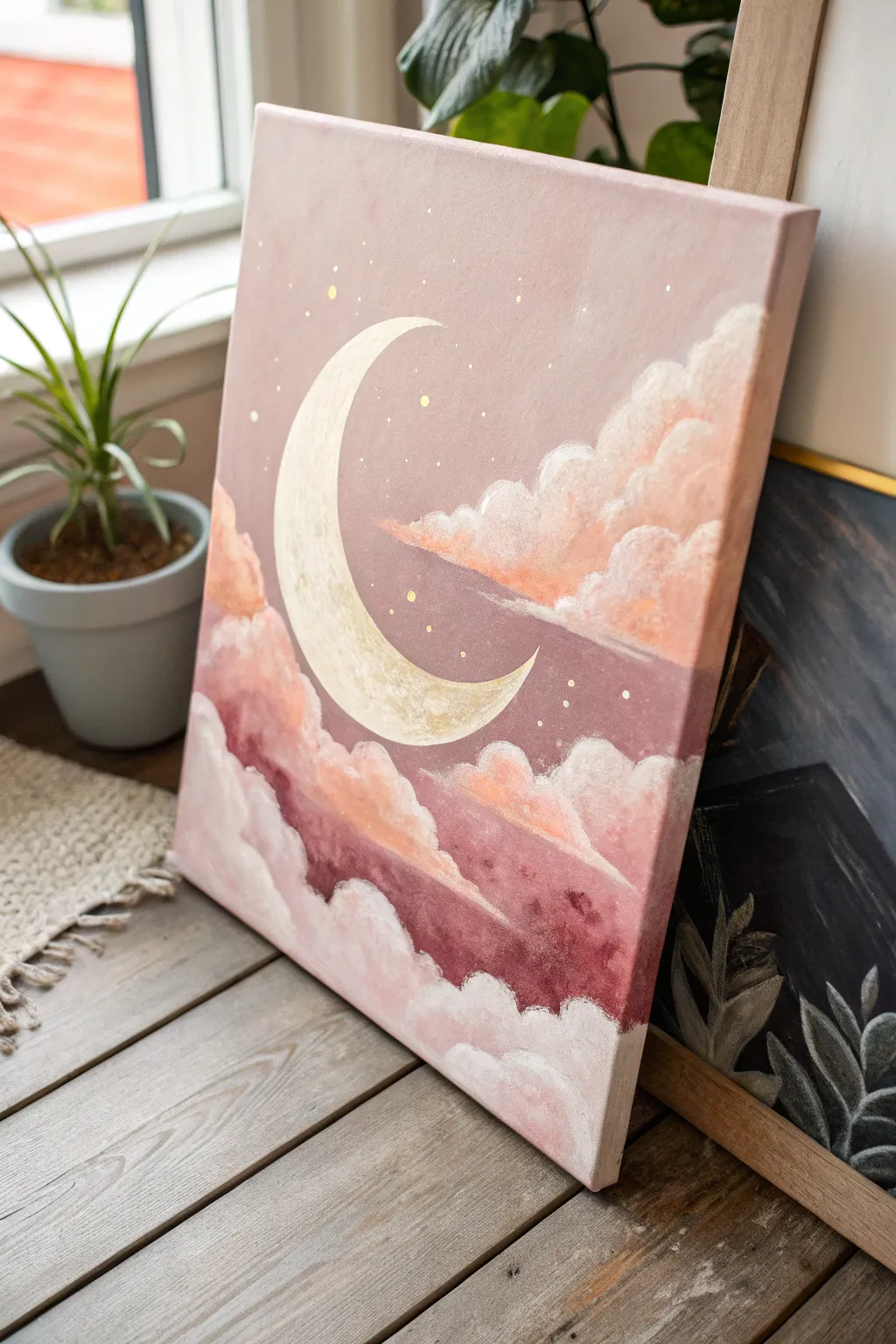 Paint a glowing crescent moon drifting through dreamy pink clouds on a simple canvas.
