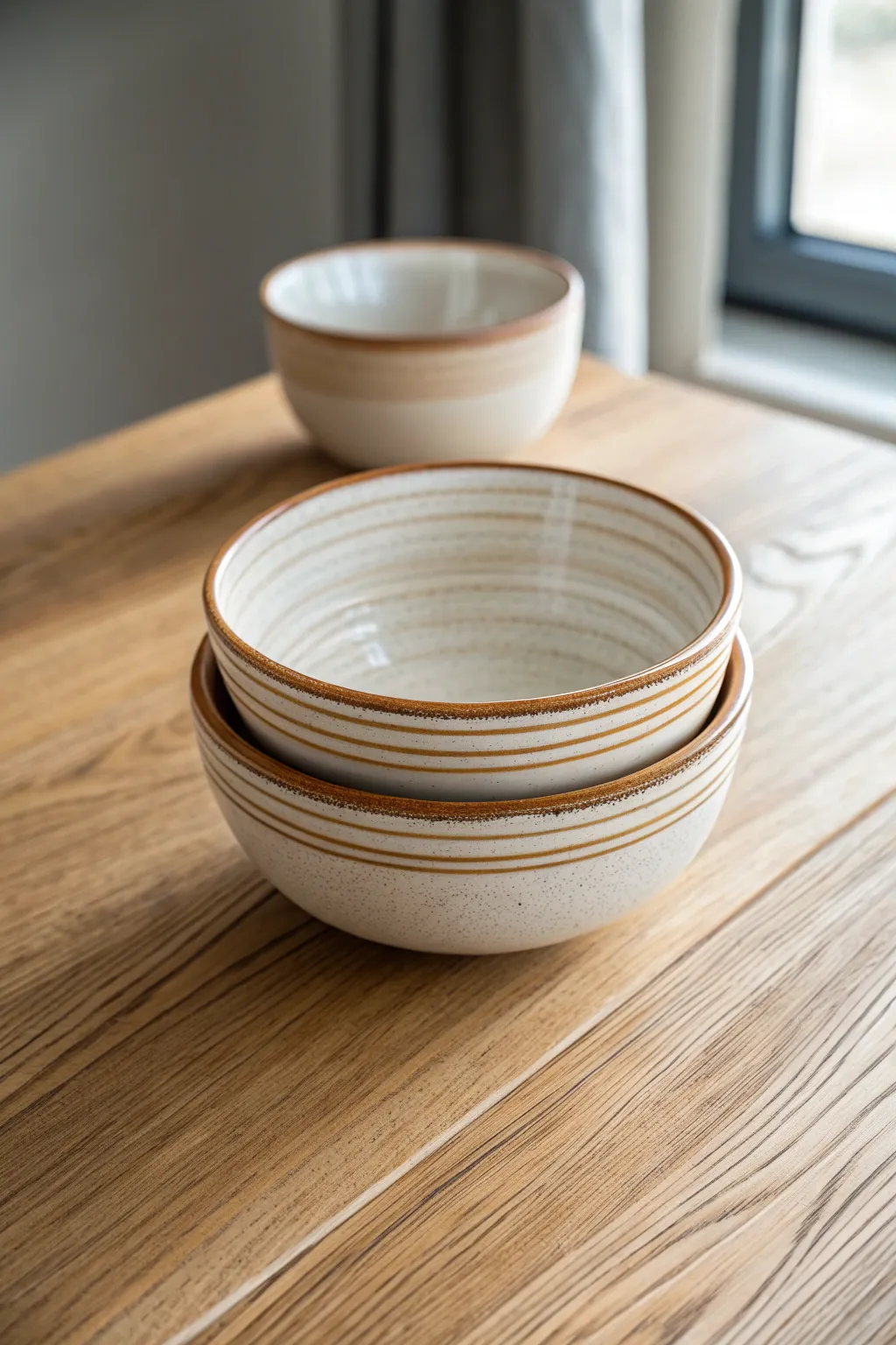 Classic rim stripes: thin and bold bands on stacked handmade bowls, clean minimalist contrast