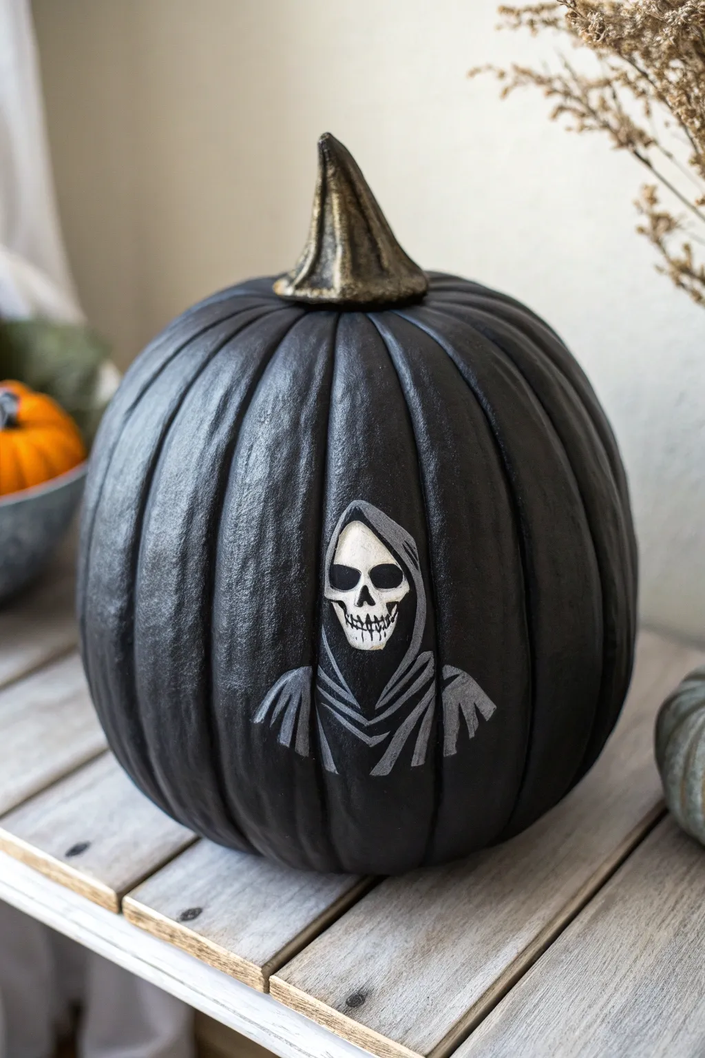 Matte-black grim reaper pumpkin with crisp hood folds and a pale skull face, minimalist mood