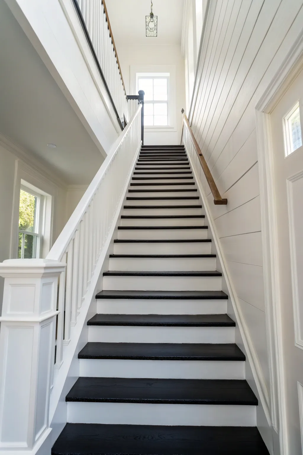 High-contrast black treads and white risers create a striking minimalist staircase pattern.