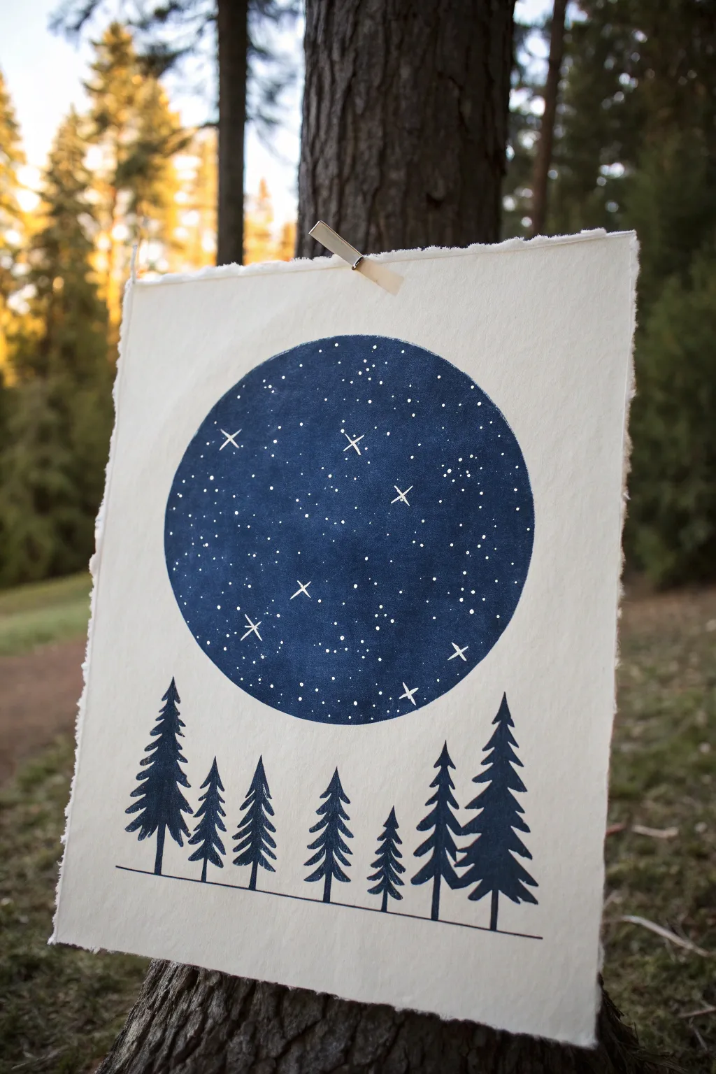 Minimal pine silhouettes in a circle with starry night dots, a crisp high-contrast drawing idea.