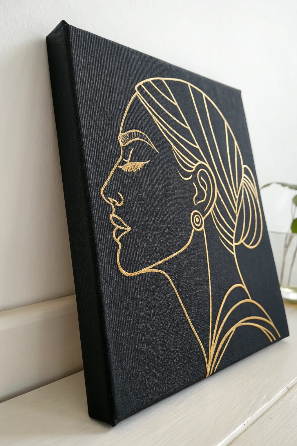 Minimal black canvas with a single gold line portrait for chic Scandinavian boho glam.