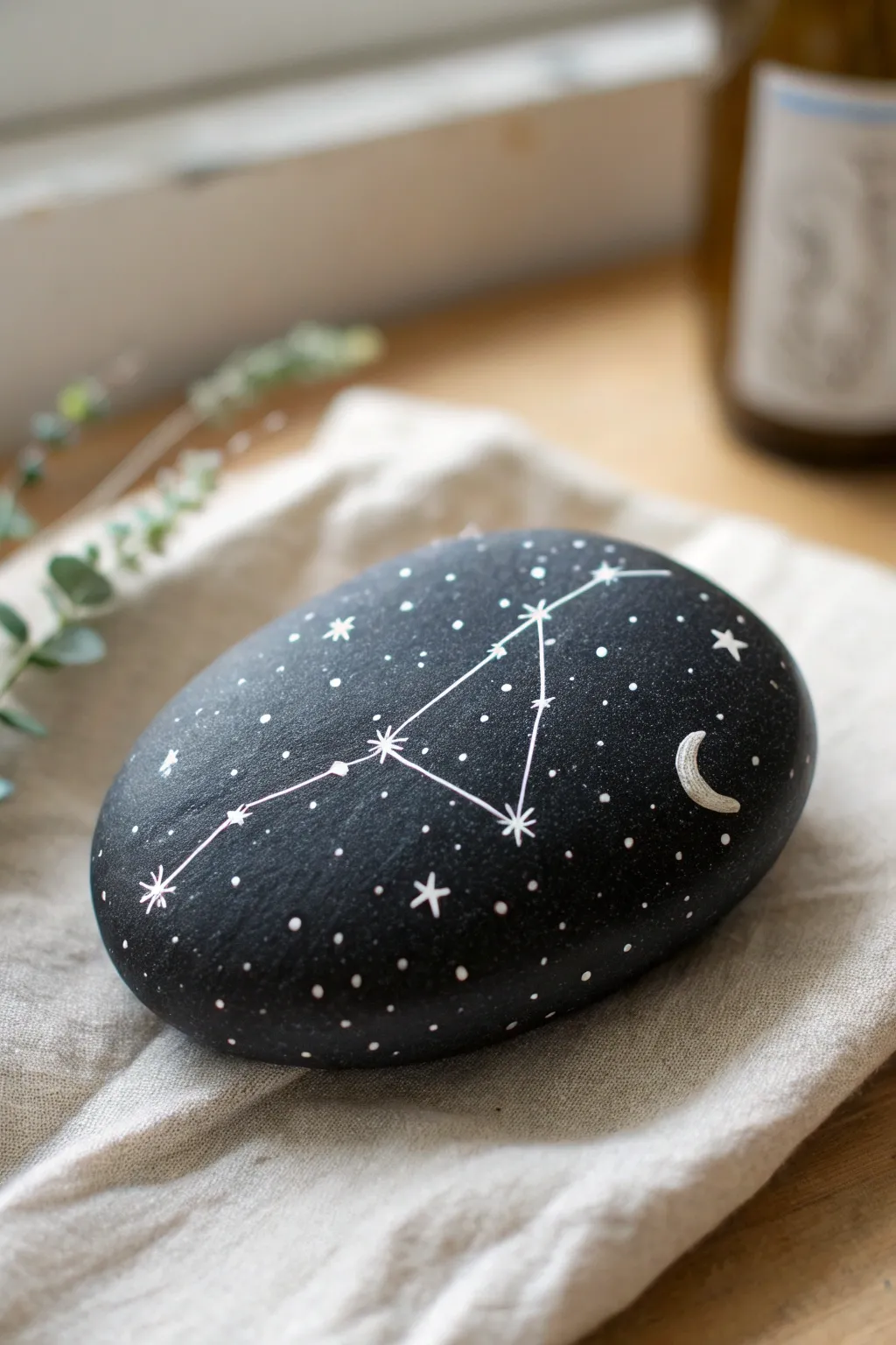 Starry constellation details on a sleek black stone for a minimalist night-sky rock art idea