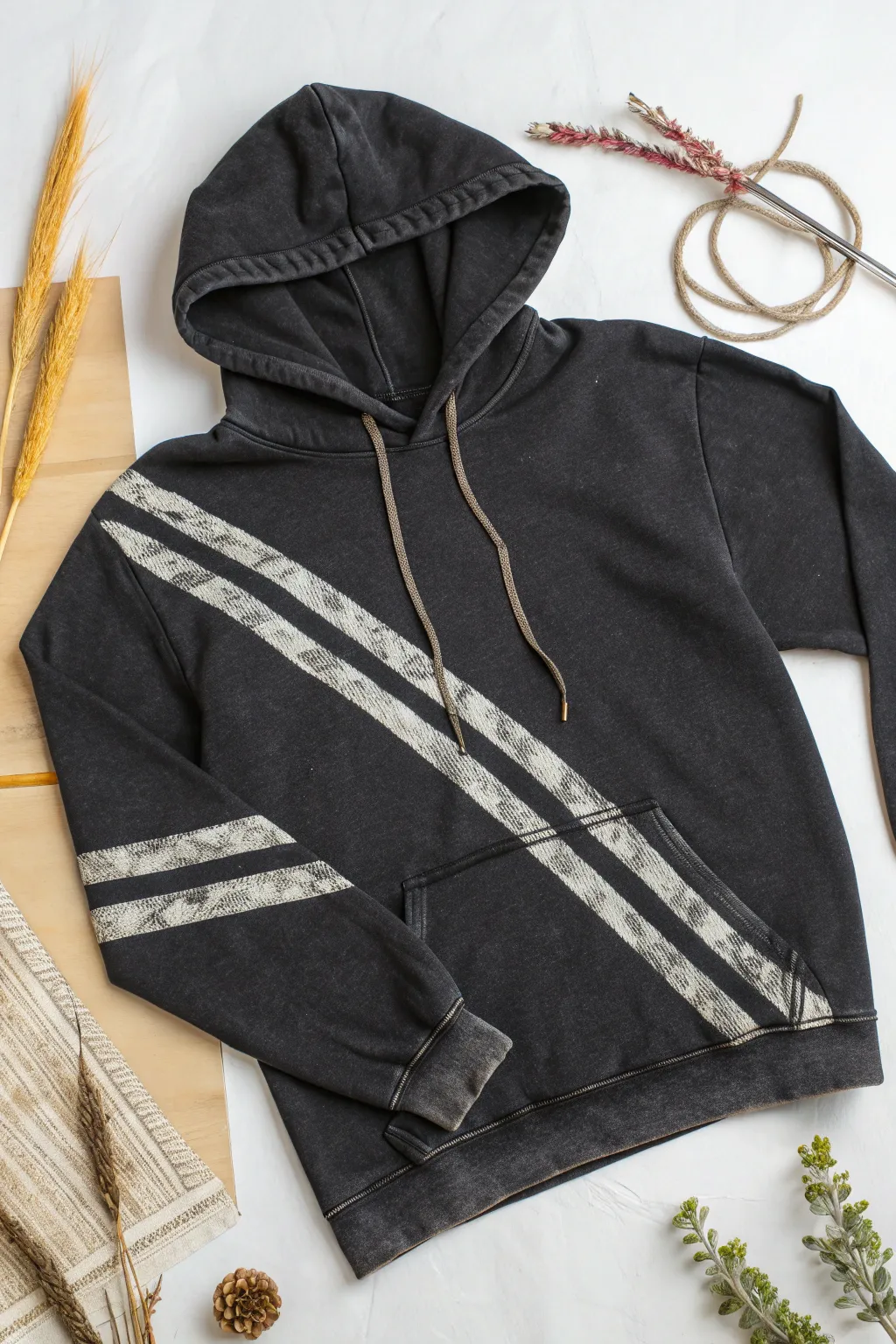 Crisp painters tape stripes meet soft, weathered bleach for a bold DIY hoodie flat lay.
