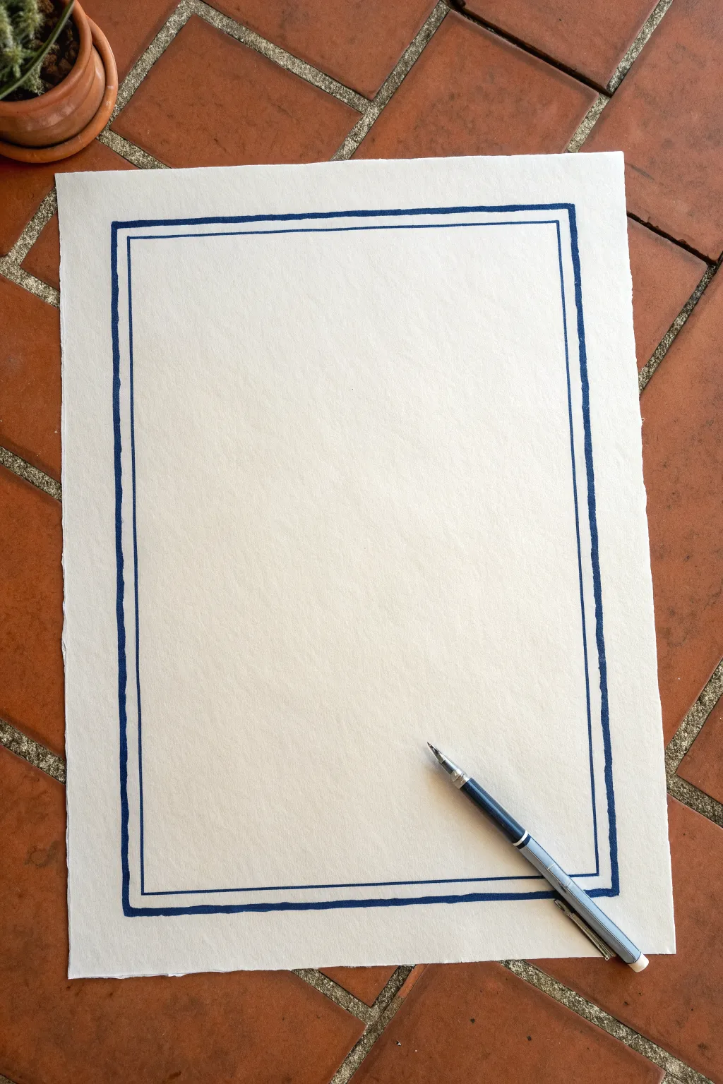 Dashed cut line border idea: bold indigo dashes on warm paper with a pen mid-stroke