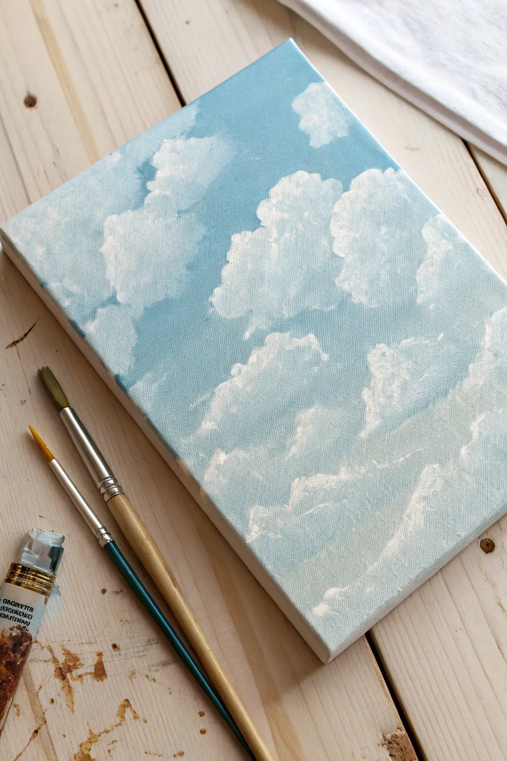 Cloud study on a canvas board with simple tools, minimalist Nordic styling and soft boho warmth