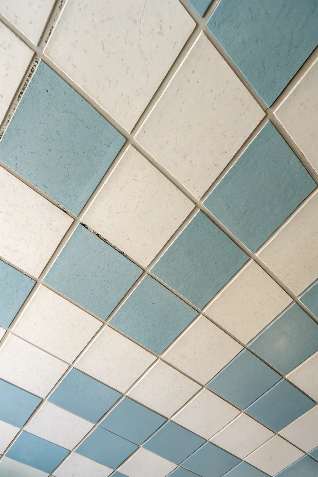 Crisp two-tone checkerboard ceiling tiles in cream and muted blue for an easy painted update