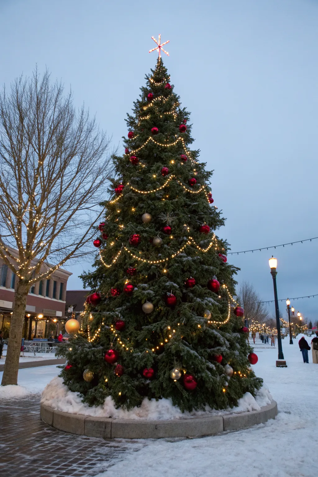 A glowing town-square evergreen lights up fresh snow, capturing cozy Nordic holiday magic.