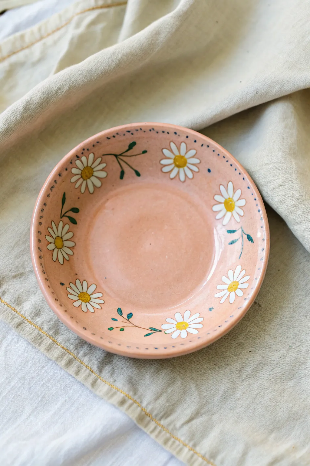 Dainty daisy ring around the rim makes this sweet saucer an easy, charming pottery paint idea.