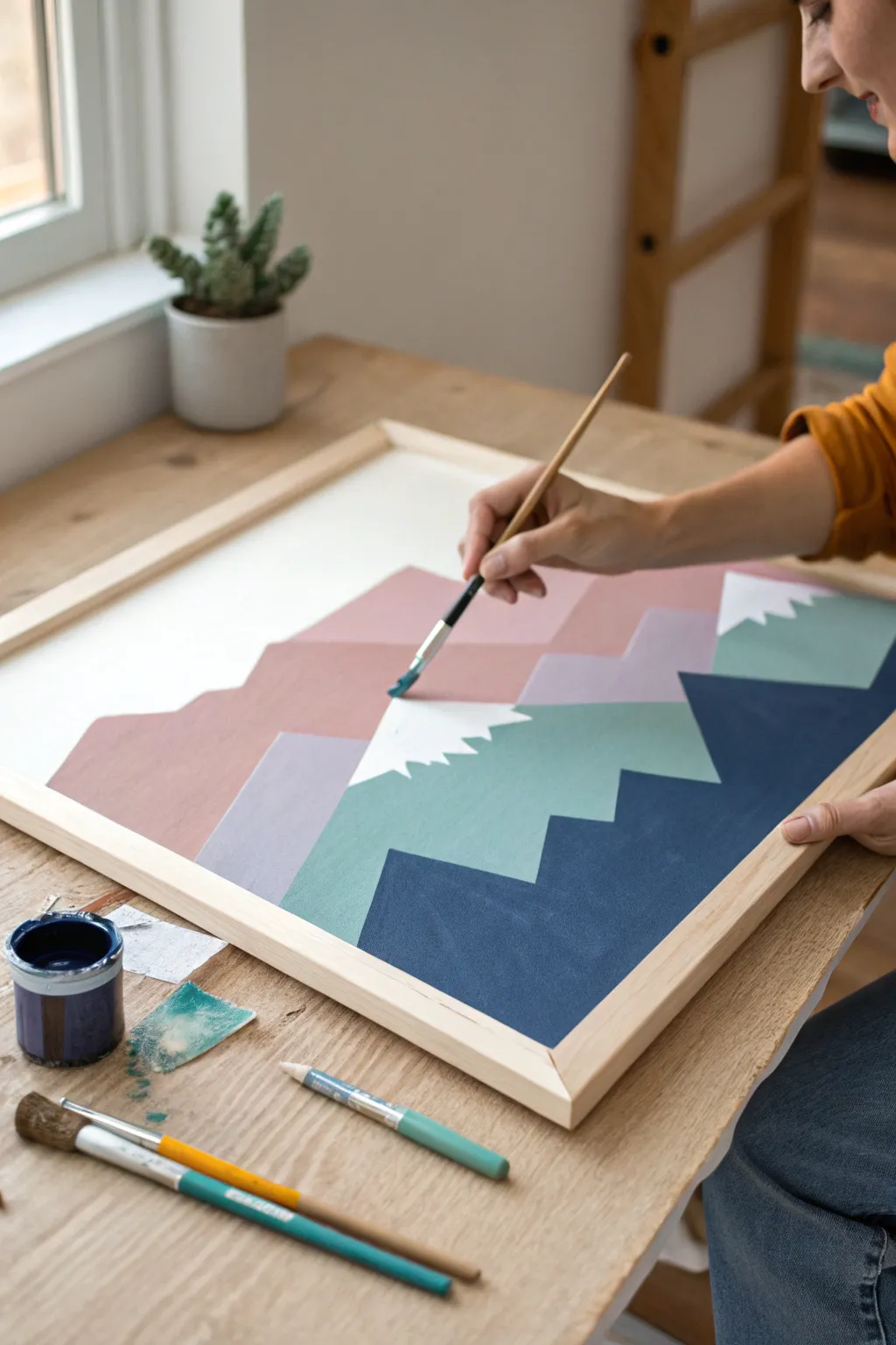 Paint simple layered mountains with crisp edges for a calm, modern boho canvas you can DIY