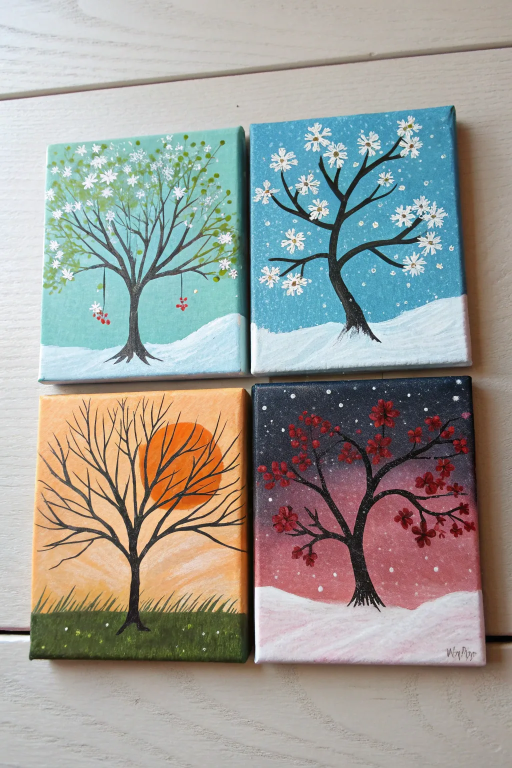 Four mini canvases become one year, season by season, with one simple tree tying it together.