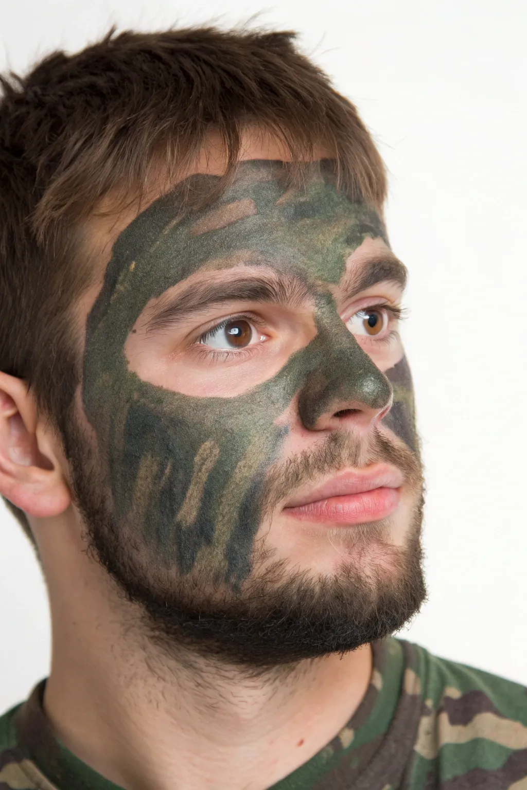 Camo smudge mask with bold green, brown, and black layers across the eyes for a rugged look.
