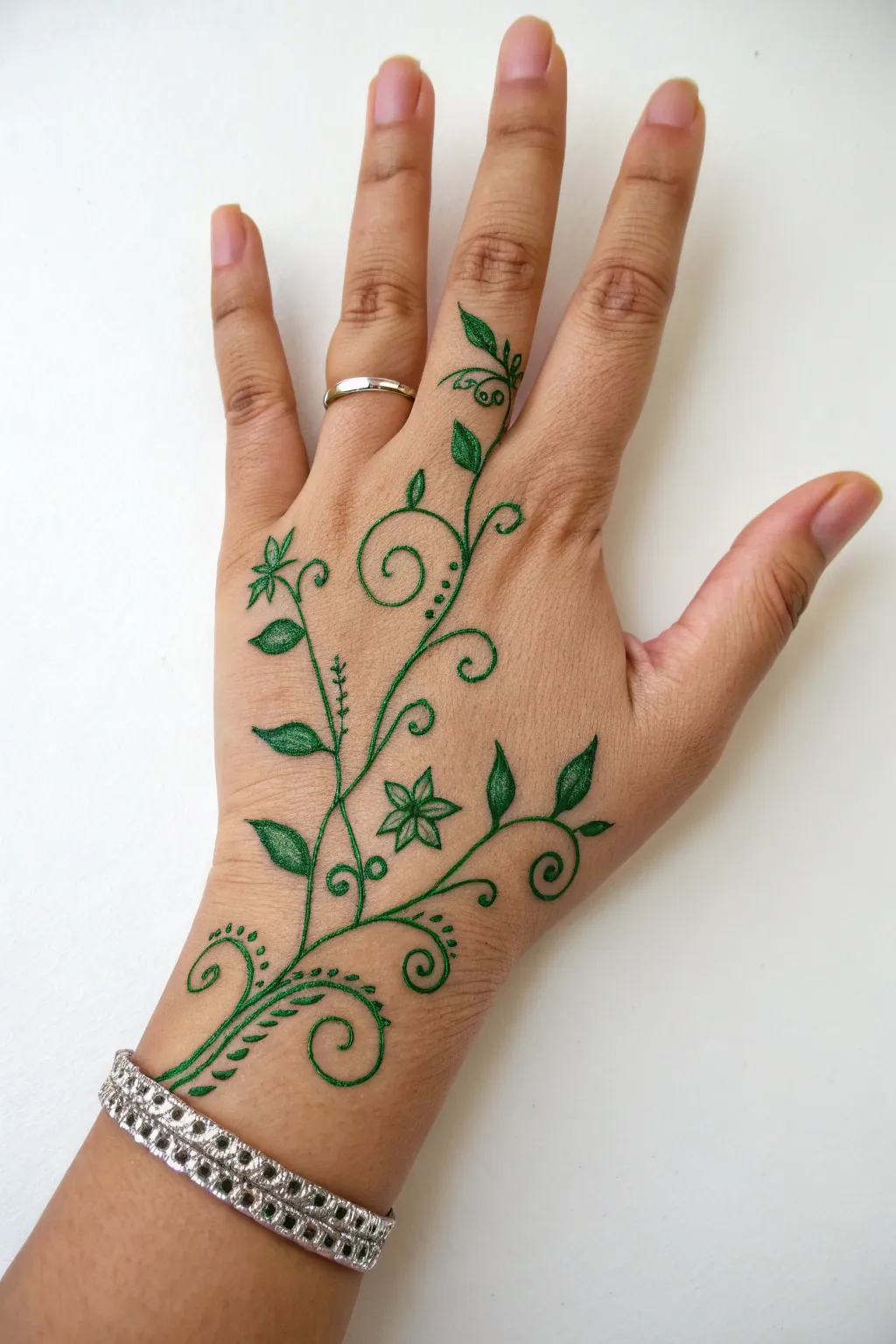 Emerald vine doodle wraps from thumb to wrist like a bracelet, minimalist and beautifully bold