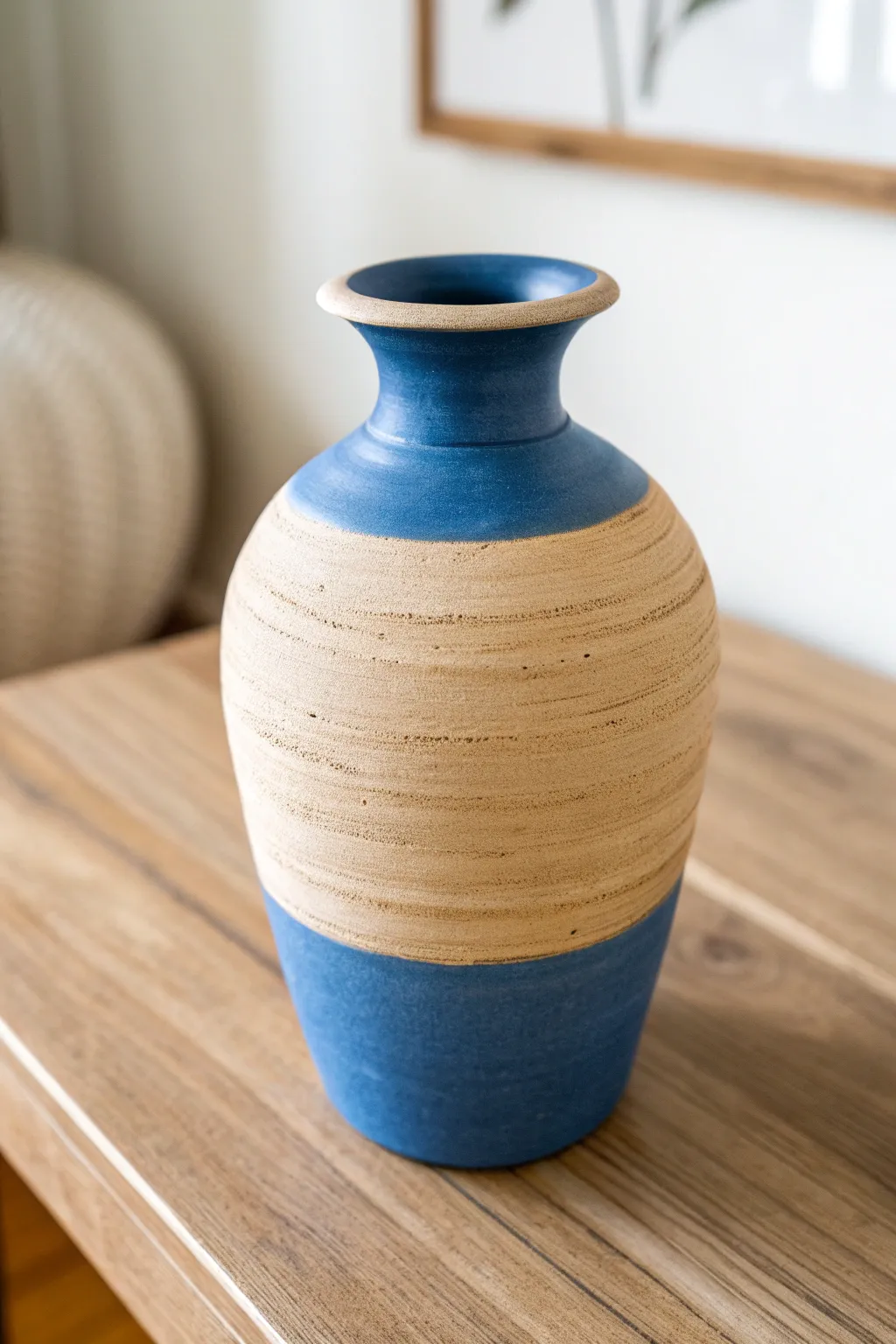 Two-tone color block mud vase on oak table, bold contrast with soft Scandinavian-boho calm.