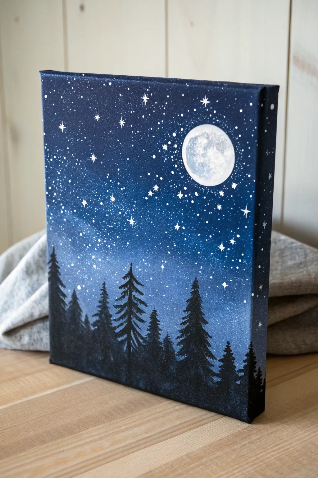 Beginner-friendly starry night canvas with bold moon glow and simple pine silhouettes.
