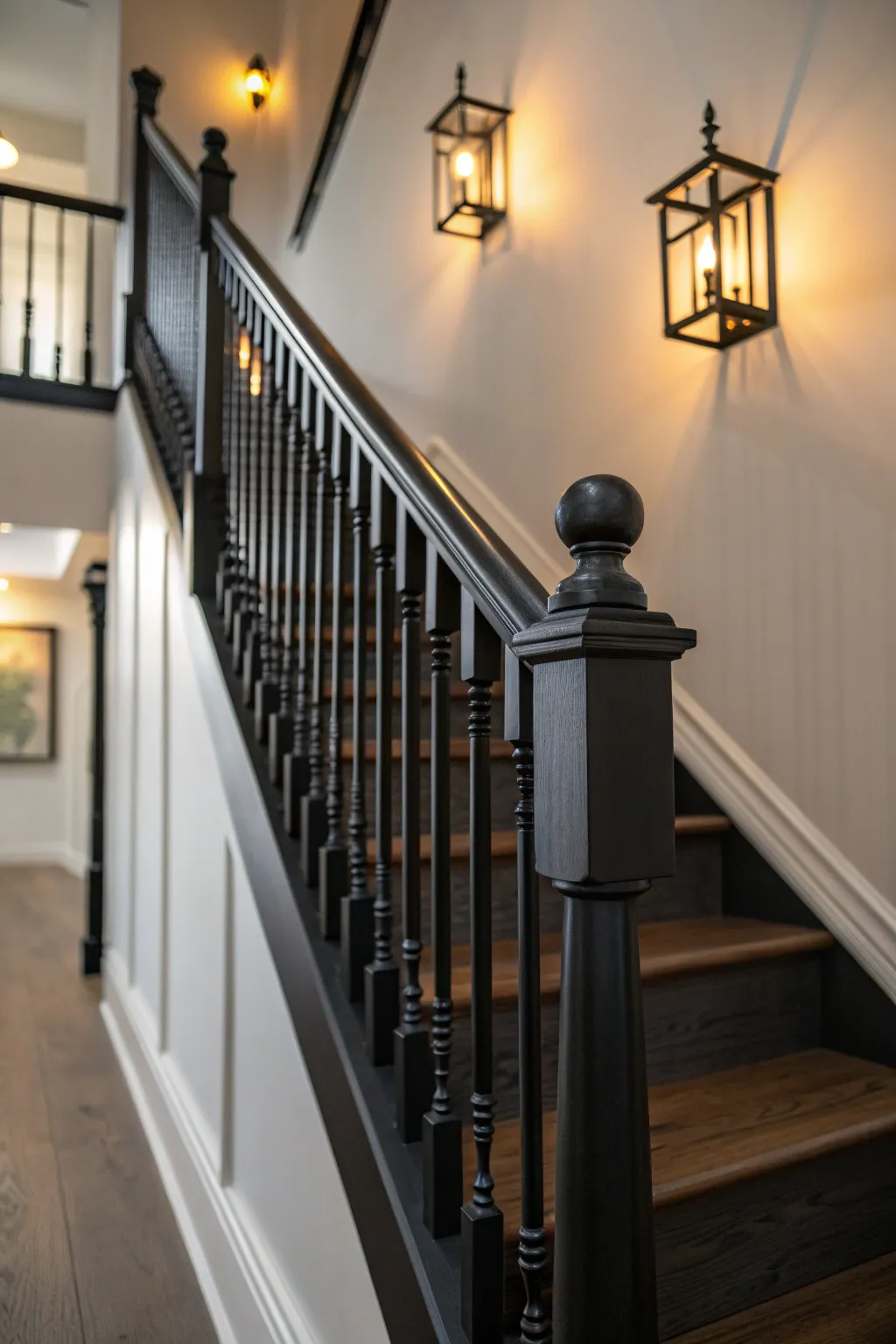 Matte black staircase spindles under warm light for moody drama and crisp contrast.