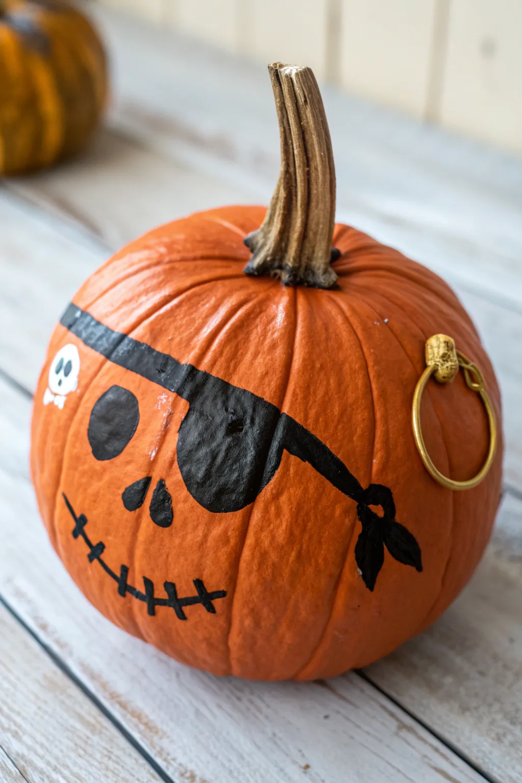 Close-up pirate pumpkin with bold eyepatch and gold hoop earring in minimalist boho style