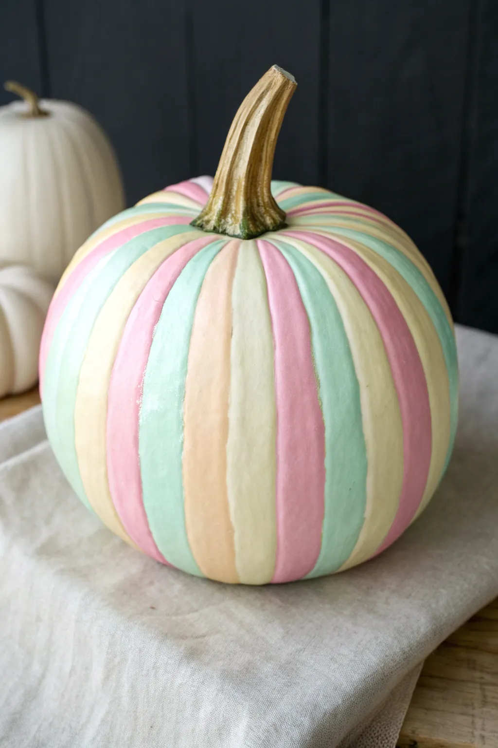 Preppy candy-stripe pumpkin in pastel pink, mint, and pale yellow with a chic gold stem