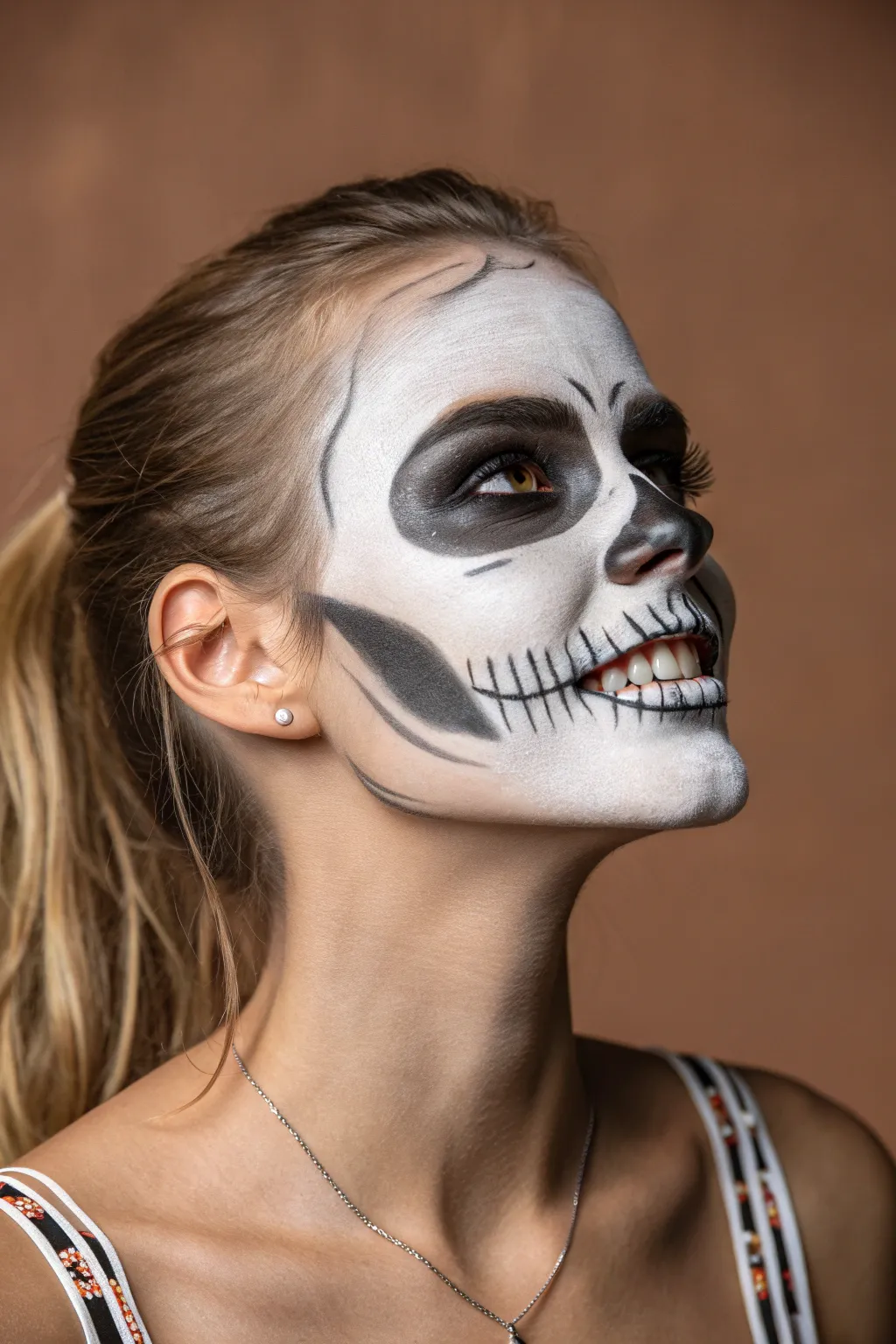 Smoky shaded skull face paint with crisp teeth lines for realistic bone depth and bold contrast